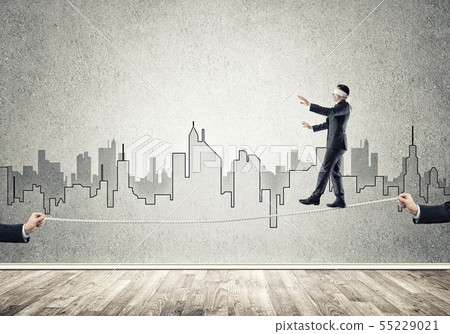 Business concept of risk support and assistance with man balancing on rope 55229021