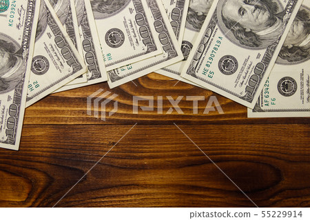 One hundred dollars bills on wooden desk 55229914