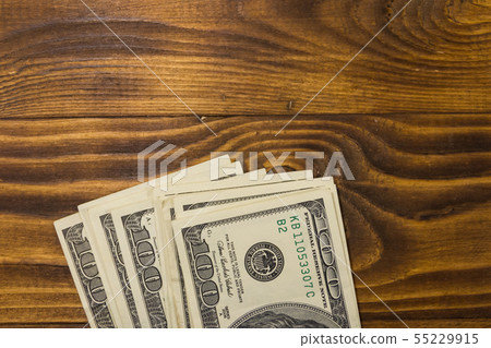 One hundred dollars bills on wooden desk 55229915