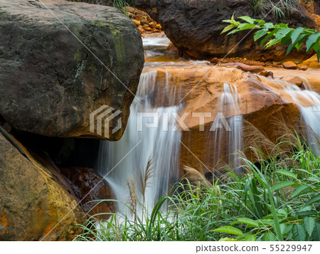 Smooth flowing water falling over rocks  55229947