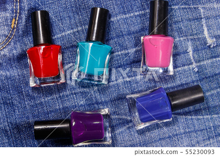 Set of nail polish bottles on jeans background Set of nail polish bottles on jeans background 55230093