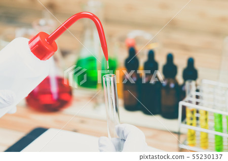 Researcher is dropping the reagent into test tube. Researcher is dropping the reagent into test tube. 55230137