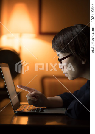 使用計算機的婦女在晚上 55230590
