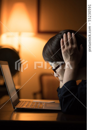 Woman using a computer at night Woman using a computer at night 55230591