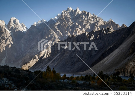 Sunlight lit massif mountains against clear sky 55233114