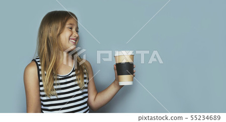 Smiling girl giving, showing coffeecup closeup side view 55234689