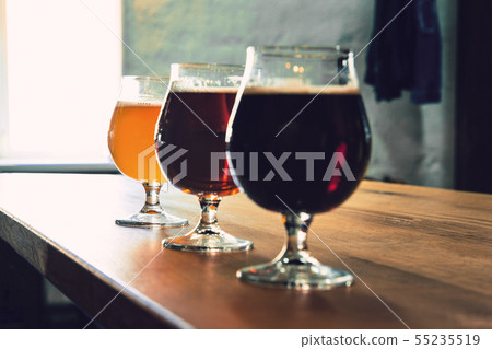 Glasses of different kinds of beer on wooden background 55235519