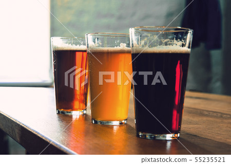 Glasses of different kinds of beer on wooden background 55235521