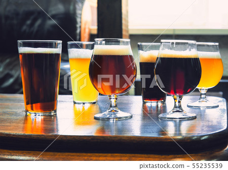 Glasses of different kinds of beer on wooden background 55235539