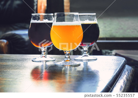 Glasses of different kinds of beer on wooden background Glasses of different kinds of beer on wooden background 55235557
