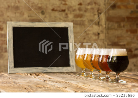 Glasses of different kinds of beer on wooden background Glasses of different kinds of beer on wooden background 55235686