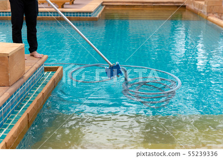 Worker cleaning swimming pool with vacuum tube in the morning. Worker cleaning swimming pool with vacuum tube in the morning. 55239336
