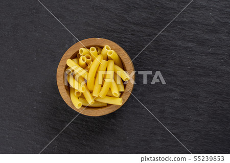 Raw macaroni pasta on grey stone Raw macaroni pasta on grey stone 55239853