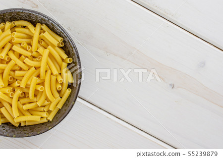 Raw macaroni pasta on grey wood Raw macaroni pasta on grey wood 55239879