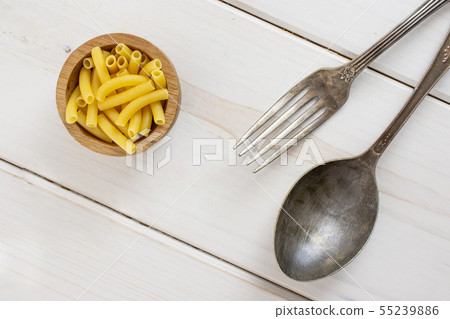 Raw macaroni pasta on grey wood 55239886