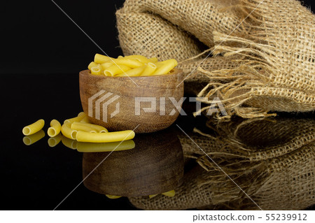 Raw macaroni pasta isolated on black glass 55239912