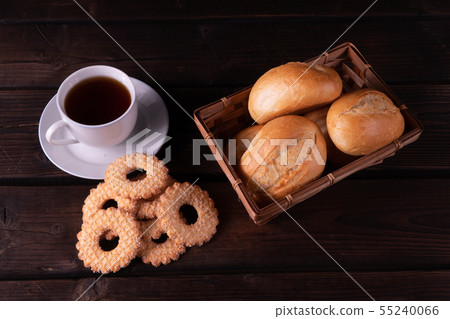Cap of tea, home made cookies and buns in bread 55240066