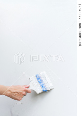 Female hand with brush paints a white sheet. Clear sheet. Place for text. 55243071
