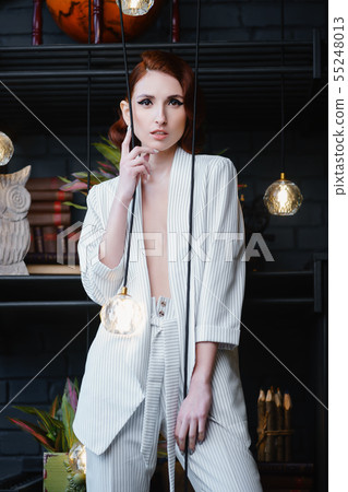 Pretty redhead thin young woman in white unbuttoned pant suit 55248013