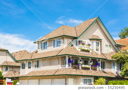 Top of big luxury residential house on blue sky Top of big luxury residential house on blue sky 55250495