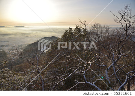 The morning sun shines from the large and small mountain south side peaks, the morning foggy countryside after the snowfall and the distant Mt. Mitaka and Mt. Tsukuba 55251661