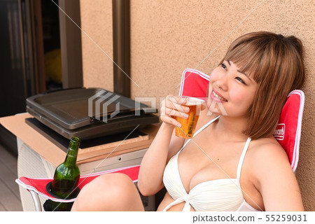 泳裝的四名婦女喝在遊廊的啤酒 泳裝的四名婦女喝在遊廊的啤酒 55259031