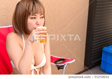 泳裝的三名婦女喝在遊廊的啤酒 55259032
