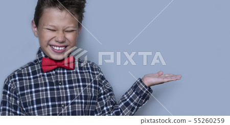 Small schoolchild showing something with palm of hand Small schoolchild showing something with palm of hand 55260259