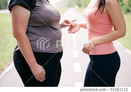 Overweight woman take slimming pills from friend 55261112