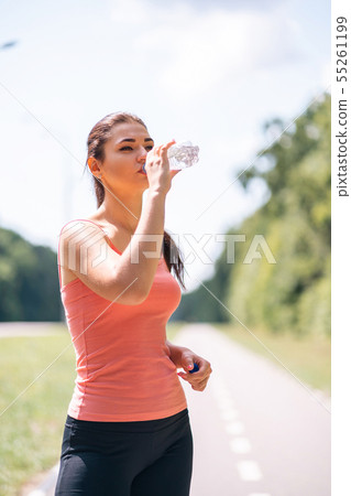 Young fit woman drink water after outdoor jogging 55261199