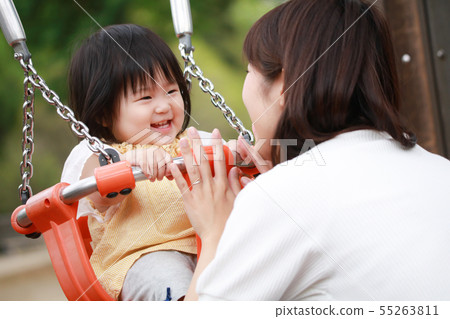 Parents and children playing on a swing 55263811