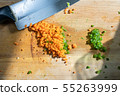 There are paprika, carrots, green peppers and knives on a wooden board. 55263999