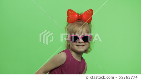 Positive girl in purple dress, sunglasses and red ribbon looking at camera 55265774