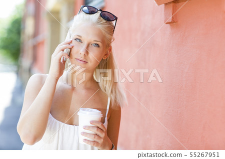 Young blonde girl talking on the phone outdoor 55267951