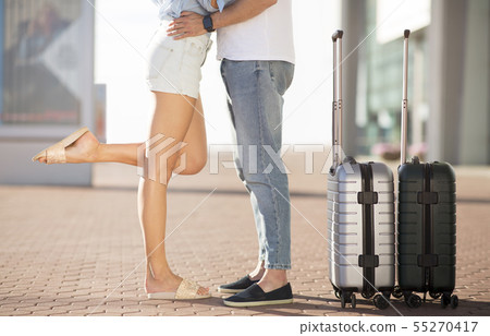 Couple kissing in airport, standing outdoors with baggage 55270417