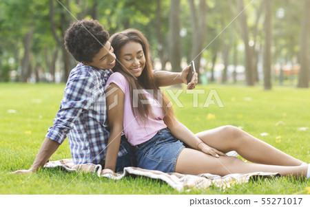 Romantic teenagers taking selfie on a date in park 55271017