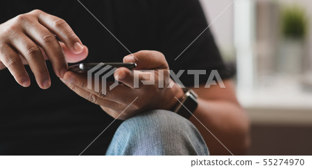 Young male touching his smartphone Young male touching his smartphone 55274970