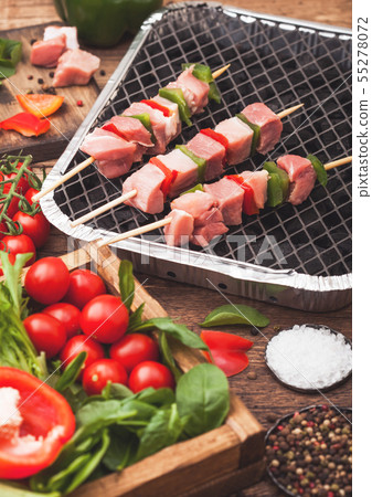 Raw pork kebab with paprika on disposable coal bbq Raw pork kebab with paprika on disposable coal bbq 55278072