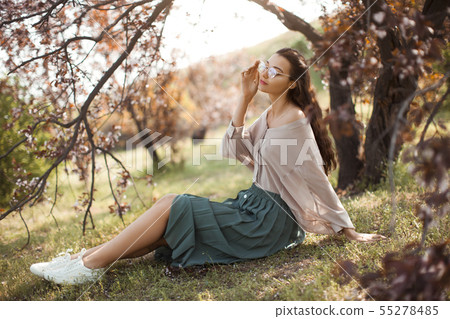 Woman Outdoors in Park Near Spring Blossom Tree Woman Outdoors in Park Near Spring Blossom Tree 55278485