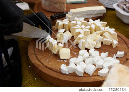 Chef-cook sliced cheese on a cutting board. Cutting ingredients closeup. Chef-cook sliced cheese on a cutting board. Cutting ingredients closeup. 55280384