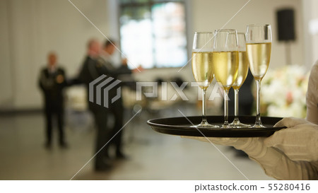 A tray with three glasses of champagne. Waiter holding a tray with a champagne glass 55280416