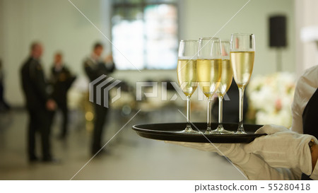 A tray with three glasses of champagne. Waiter holding a tray with a champagne glass A tray with three glasses of champagne. Waiter holding a tray with a champagne glass 55280418
