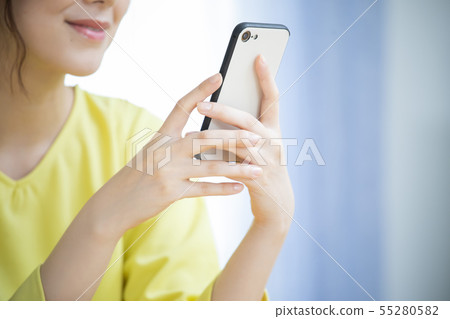 Woman operating a smartphone Woman operating a smartphone 55280582