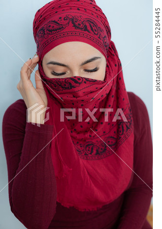 A young muslim woman ties the red handkerchief A young muslim woman ties the red handkerchief 55284445