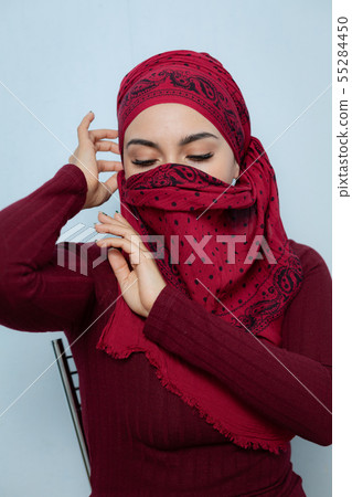 A young muslim woman ties the red handkerchief A young muslim woman ties the red handkerchief 55284450