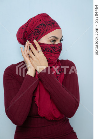 A young muslim woman ties the red handkerchief A young muslim woman ties the red handkerchief 55284464