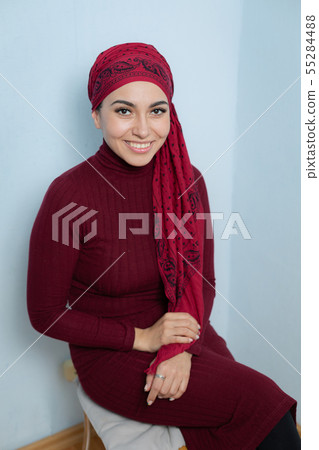 A young muslim woman ties the red handkerchief A young muslim woman ties the red handkerchief 55284488