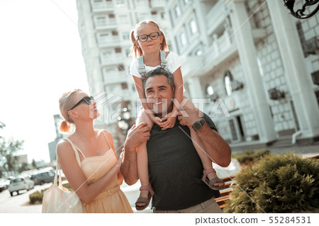 Little girl sitting on shoulders of her father. 55284531