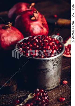 Rustic metal mug full of the pomegranate seeds 55284587
