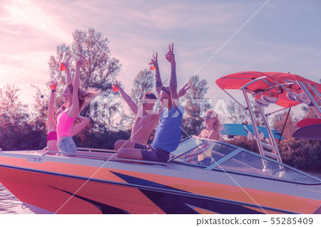 Cheerful pleased modern young people celebrating in the company of their friends 55285409